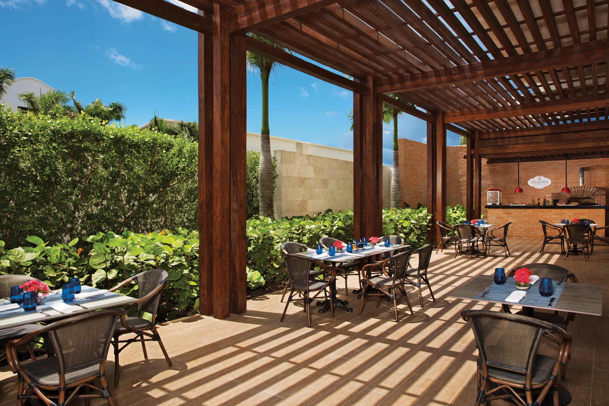 Pizzeria at Dreams Dominicus La Romana featuring freshly baked pizzas, casual outdoor dining, and family-friendly atmosphere.