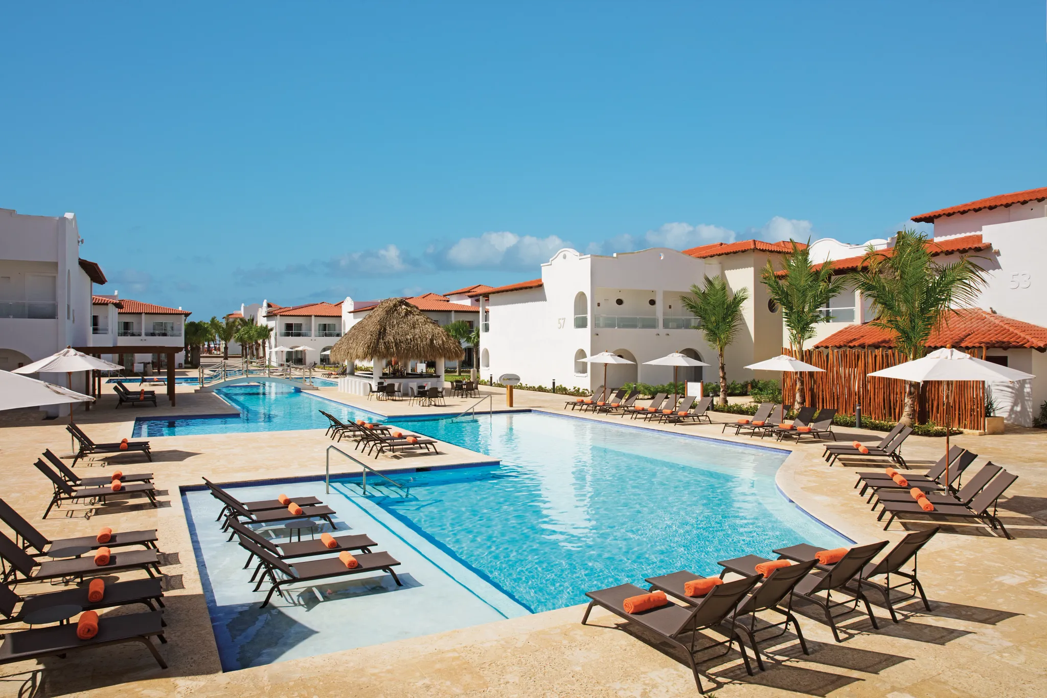Peaceful resort pool surrounded by tropical villas at Dreams Dominicus La Romana.